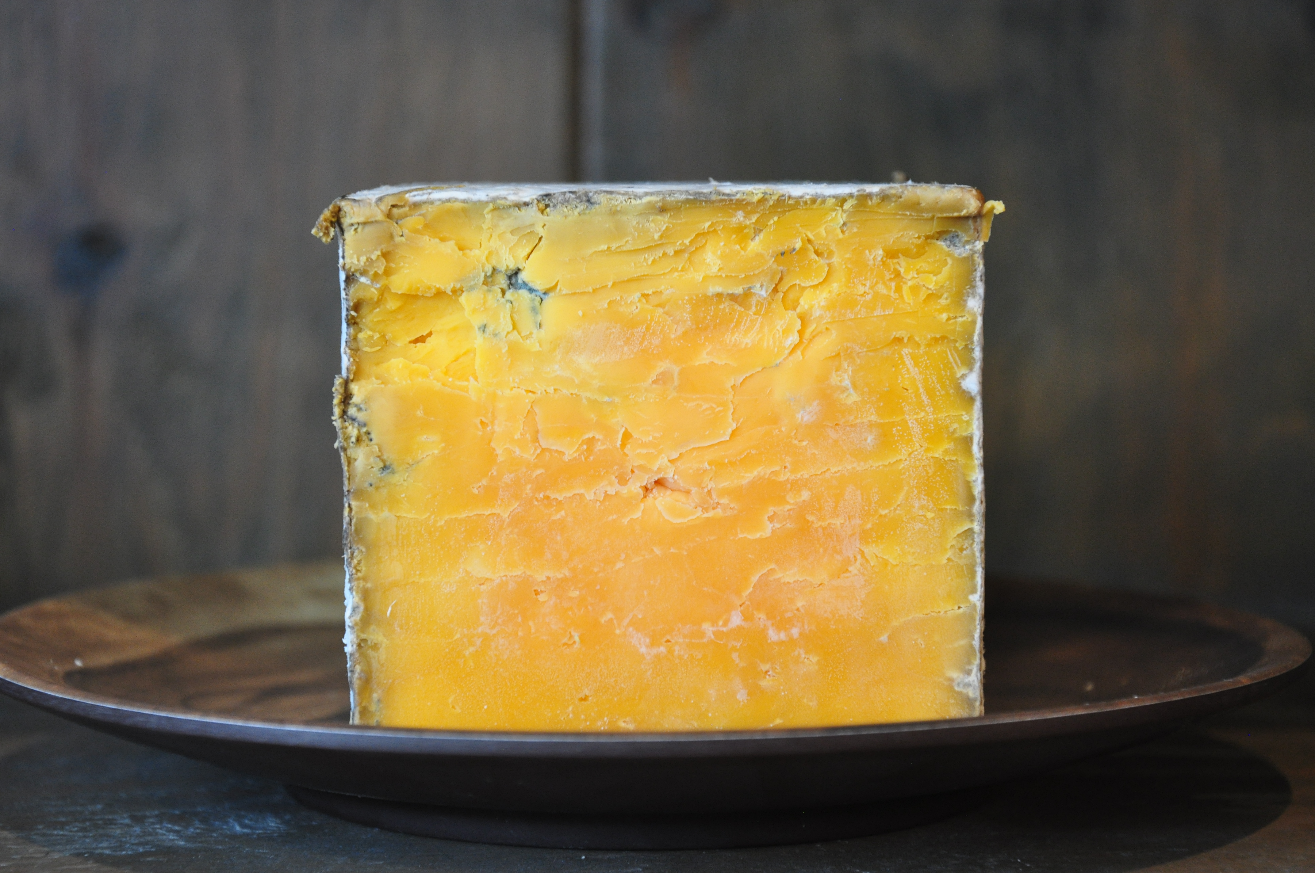 Block of Red Rock Wisconsin cheddar cheese on a cutting board